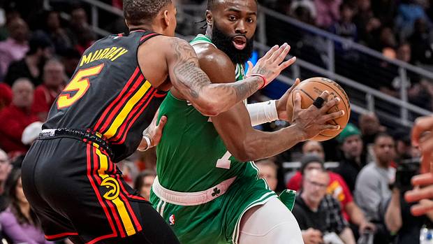 Boston Celtics guard Jaylen Brown dribbles into Atlanta Hawks guard Dejounte Murray.