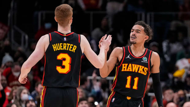 Hawks guards Kevin Huerter and Trae Young celebrate a play.