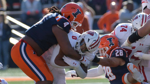 Illinois Fighting Illini defensive tackle Jer'Zhan Newton (4) tackles Wisconsin Badgers running back Braelon Allen (0) during the first half at Memorial Stadium. Mandatory Credit: Ron Johnson-USA TODAY Sports