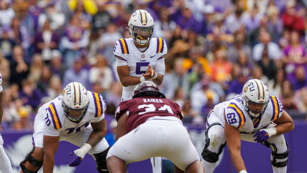 LSU Tigers quarterback Jayden Daniels (5) calls for the ball against Texas A&M Aggies defensive lineman Isaiah Raikes (34) during the second half at Tiger Stadium.