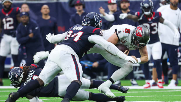 Buccaneers quarterback Baker Mayfield (6) dives for a first down as Houston Texans defensive tackle Khalil Davis (94) attempts to make a tackle during the fourth quarter at NRG Stadium.