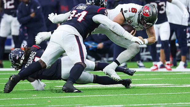 Buccaneers quarterback Baker Mayfield (6) dives for a first down as Houston Texans defensive tackle Khalil Davis (94) attempts to make a tackle during the fourth quarter at NRG Stadium.
