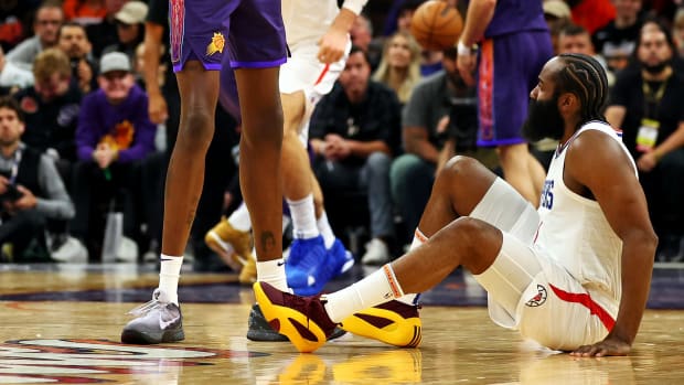 LA Clippers guard James Harden sits on the court after a foul.
