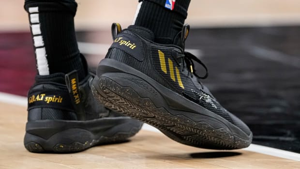 View of black and gold adidas shoes.