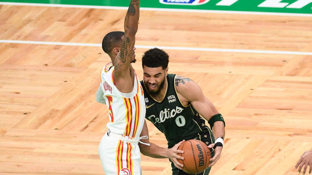 Boston Celtics forward Jayson Tatum dribbles into Atlanta Hawks guard Dejounte Murray.