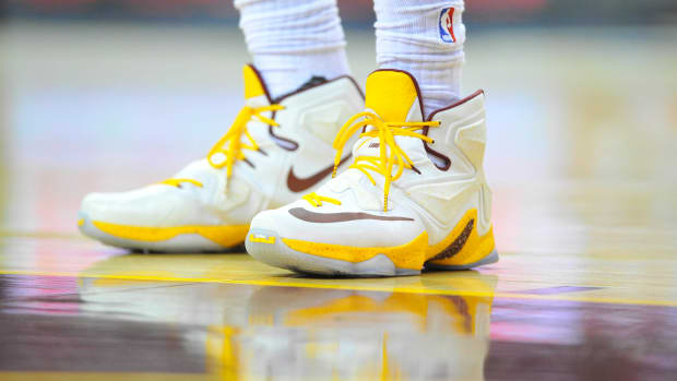 View of white and gold Nike LeBron shoes.