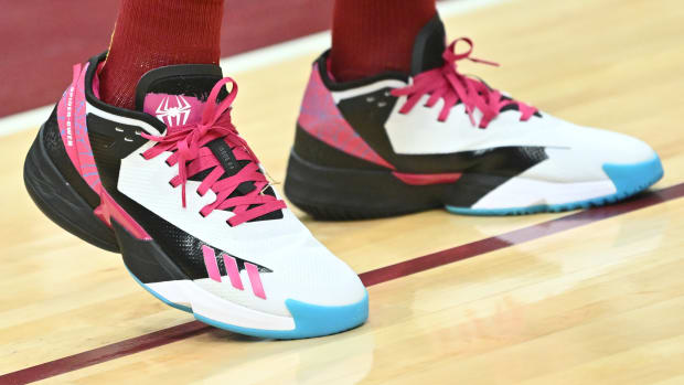 View of white, black, and pink adidas shoes.