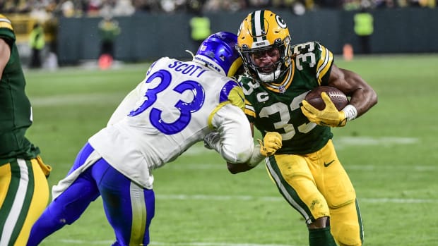 Dec 19, 2022; Green Bay, Wisconsin, USA; Green Bay Packers running back Aaron Jones (33) rushes against Los Angeles Rams safety Nick Scott (33) in the third quarter at Lambeau Field. Mandatory Credit: Benny Sieu-USA TODAY Sports
