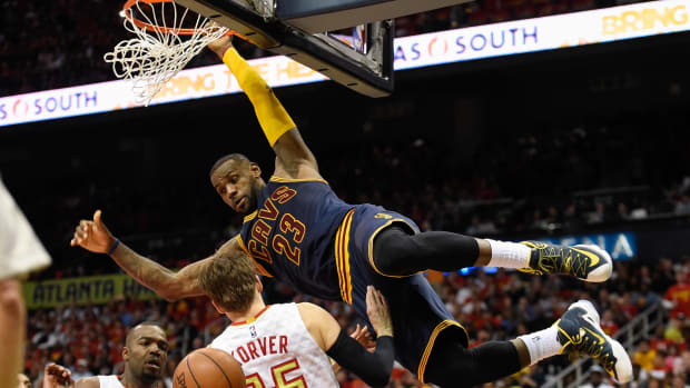 Cavaliers forward LeBron James dunks over Hawks defenders.
