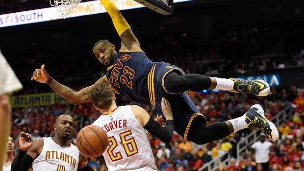 Cavaliers forward LeBron James dunks over Hawks defenders.