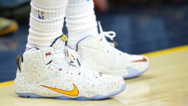 View of white and gold Nike LeBron shoes.