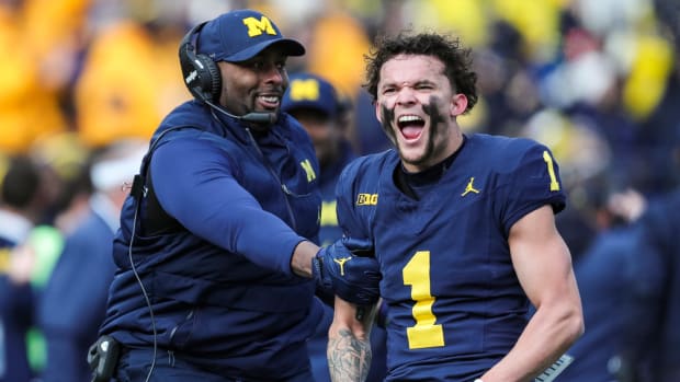 Michigan receiver Roman Wilson and acting head coach/offensive coordinator Sherrone Moore celebrate Wilson's touchdown catch against Ohio State during the first half at Michigan Stadium in Ann Arbor