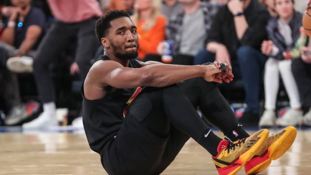 Cleveland Cavaliers guard Donovan Mitchell sits on the court after a foul.