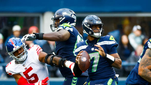 Seattle Seahawks quarterback Geno Smith (7) looks to pass as offensive tackle Charles Cross (67) backs against New York Giants defensive end Kayvon Thibodeaux (5) during the third quarter at Lumen Field.