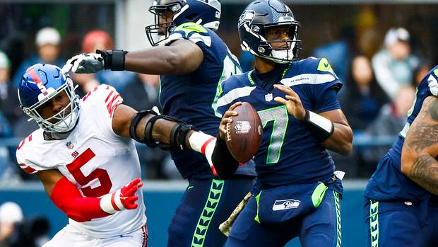 Seattle Seahawks quarterback Geno Smith (7) looks to pass as offensive tackle Charles Cross (67) backs against New York Giants defensive end Kayvon Thibodeaux (5) during the third quarter at Lumen Field.
