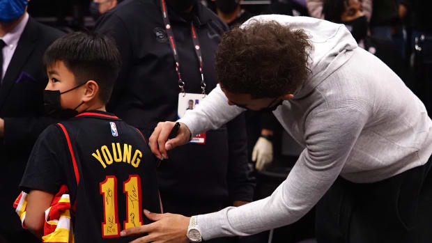 Jan 5, 2022; Sacramento, California, USA; Atlanta Hawks guard Trae Young (11) signs the jersey of a young fan after the game against the Sacramento Kings at Golden 1 Center.