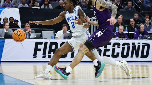 UCLA Bruins guard Dylan Andrews dribbles past Northwestern Wildcats guard Boo Buie.