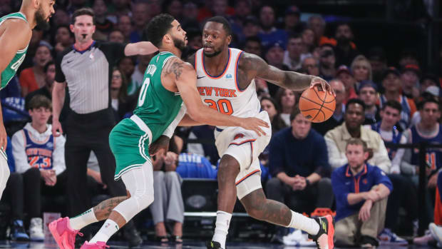 New York Knicks forward Julius Randle dribbles past Boston Celtics forward Jayson Tatum.