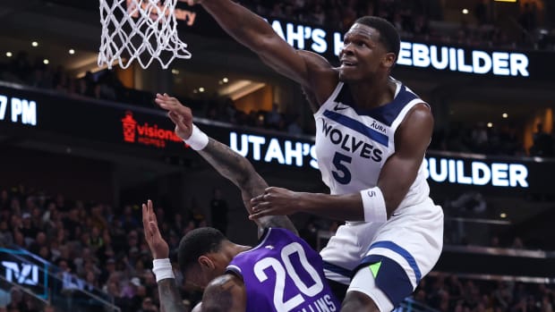 Minnesota Timberwolves guard Anthony Edwards dunks over Utah Jazz forward John Collins.