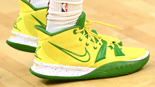 View of yellow and green Nike Kyrie shoes.