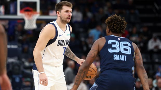 Dallas Mavericks superstar Luka Doncic being guarded by Memphis Grizzlies' Marcus Smart.