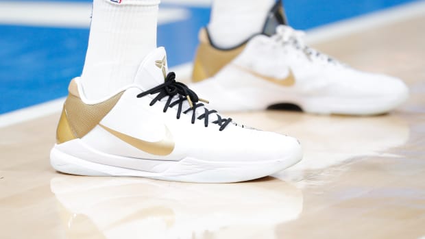 White and gold Nike Kobe 5 shoes.