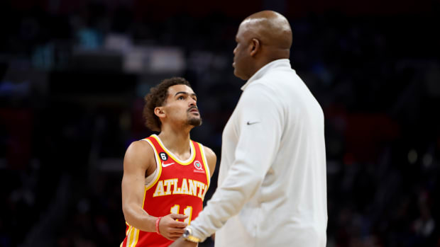Hawks coach Nate McMillan greets Trae Young during a timeout.