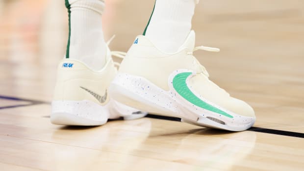 View of Giannis Antetokounmpo's cream and green Nike shoes.