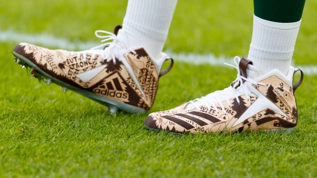 View of Aaron Rodgers' brown and white Adidas cleats.