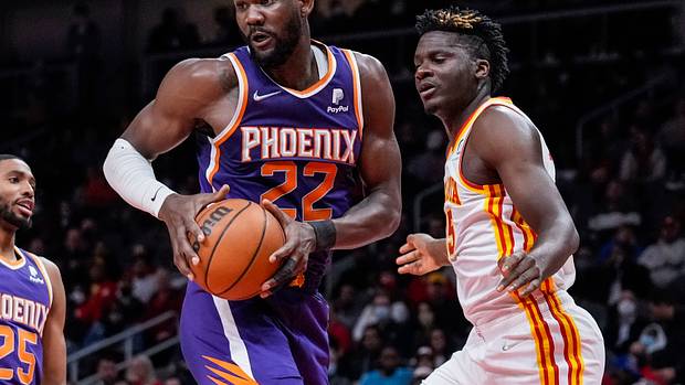 Deandre Ayton controls a rebound over Clint Capela.