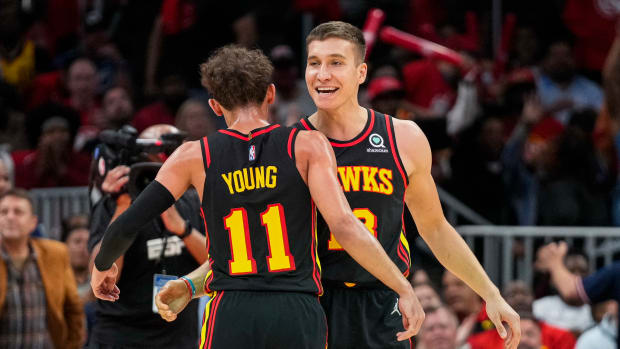 Apr 13, 2022; Atlanta, Georgia, USA; Atlanta Hawks guard Trae Young (11) reacts with guard Bogdan Bogdanovic (13) after a basket against the Charlotte Hornets during the second half at State Farm Arena.