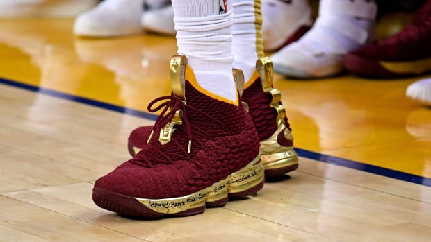 View of maroon and gold Nike LeBron shoes.