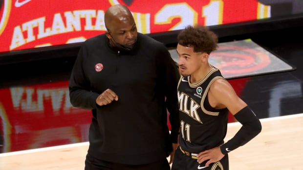 Hawks head coach Nate McMillan speaking with Trae Young.