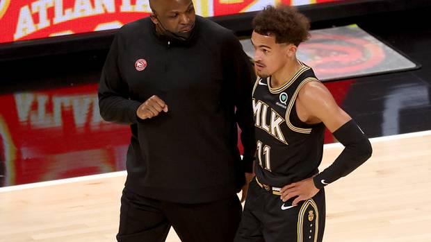Hawks head coach Nate McMillan speaking with Trae Young.