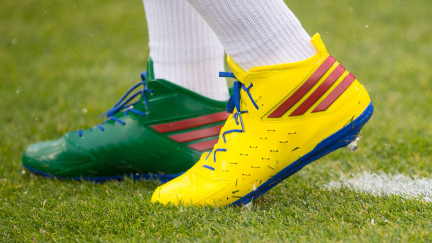 View of Aaron Rodgers' green and yellow Adidas cleats.