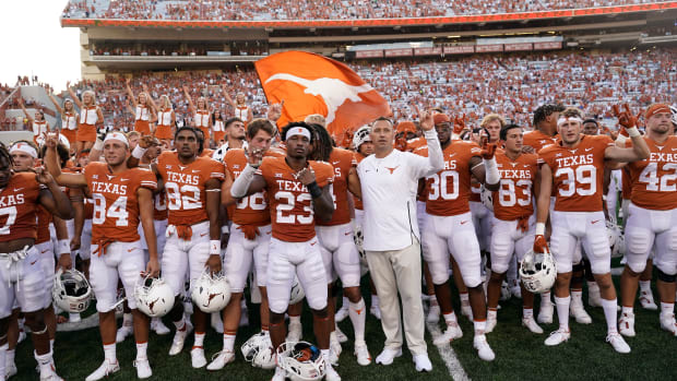 Texas football team salutes fans at end of game.