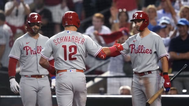 Philadelphia Phillies designated hitter Kyle Schwarber (12) celebrates with shortstop Trea Turner (right) and first baseman Bryce Harper (left) after hitting a home run during the fourth inning against the Arizona Diamondbacks in game four of the NLCS of the 2023 MLB playoffs at Chase Field in Phoenix on Oct. 20, 2023.  