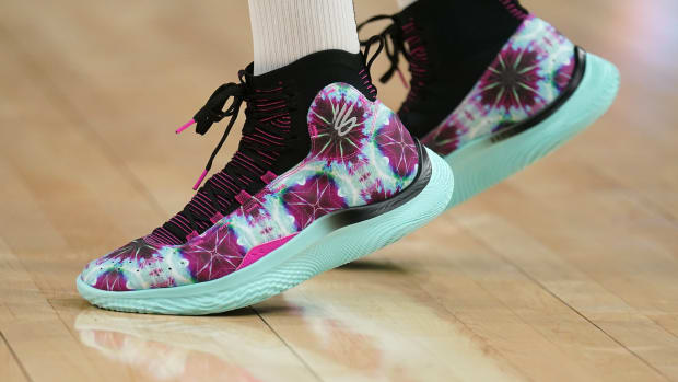 Golden State Warriors guard Stephen Curry's purple and green Under Armour sneakers.