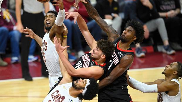 Cavaliers guard Donovan Mitchell and center Jarrett Allen reach for a rebound beside Rockets center Alperen Sengun and forward Tari Eason.