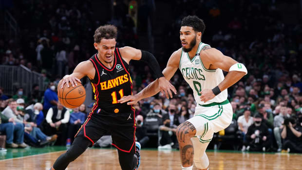 Atlanta Hawks guard Trae Young dribbles past Boston Celtics forward Jayson Tatum.