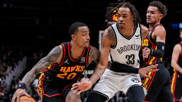 Atlanta Hawks forward John Collins tries to dribble past Brooklyn Nets forward Nic Claxton.