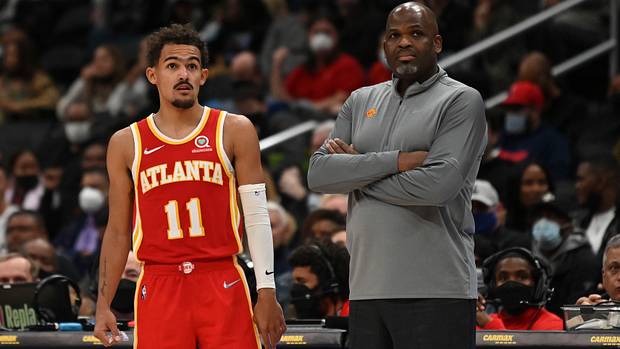 Trae Young standing beside Nate McMillan.
