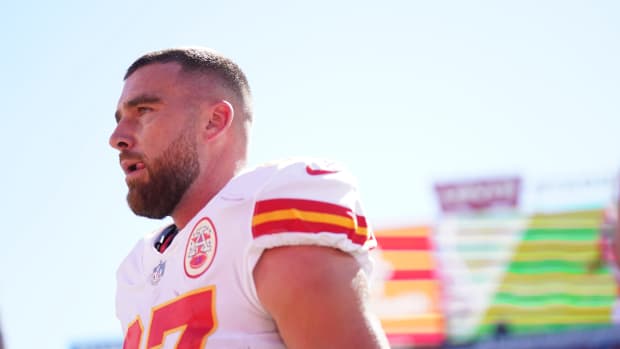 Travis Kelce stands on the sideline.