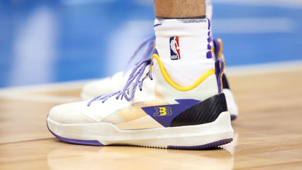 Lonzo Ball's white, purple, and gold basketball shoes.