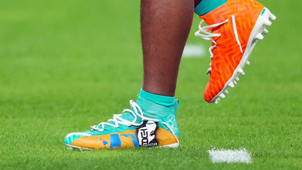 Miami Dolphins quarterback Tua Tagovailoa's green and orange adidas cleats.