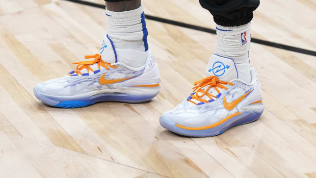 View of white, orange, and blue Nike shoes.