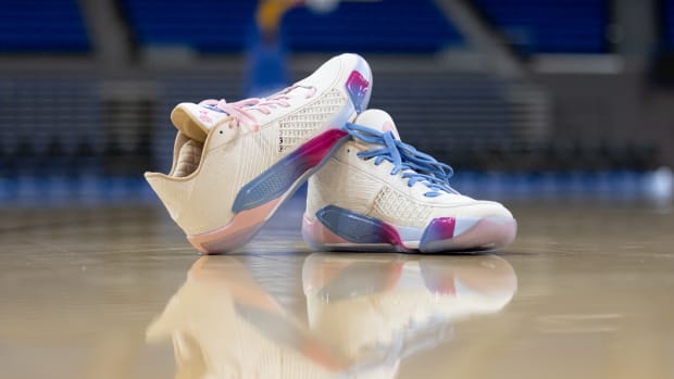 White and pink Air Jordan sneakers on the UCLA basketball court.