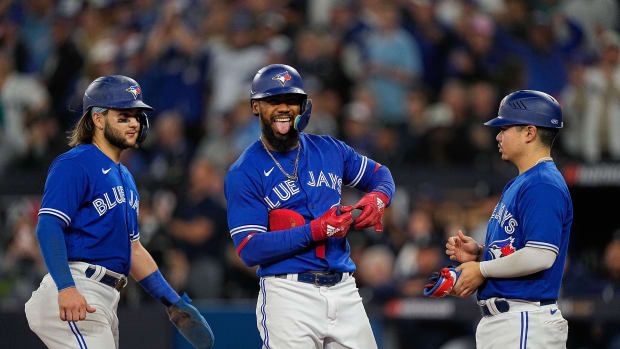 Oct 8, 2022; Toronto, Ontario, CAN; Toronto Blue Jays right fielder Teoscar Hernandez (37) hands off his gear to the bat boy after being hit by a pitch with the bases loaded as shortstop Bo Bichette (11) scores in the fifth inning during game two of the Wild Card series for the 2022 MLB Playoffs at Rogers Centre. Mandatory Credit: John E. Sokolowski-USA TODAY Sports
