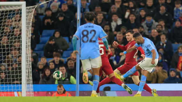 Riyad Mahrez pictured (right) shooting to score for Manchester City against Liverpool in December 2022