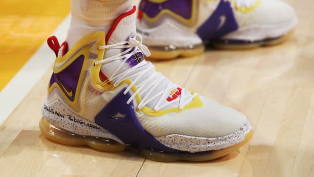 View of white, purple, and gold Nike LeBron 19 shoes.